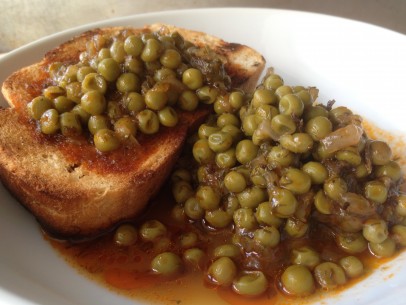 Greek peas piled high on top of a piece of grilled bread 