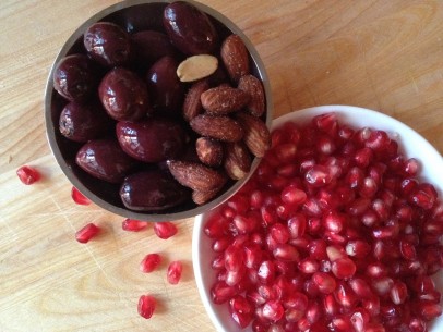 snack of salty almonds, kalamata olive and sweet pomegranate seeds