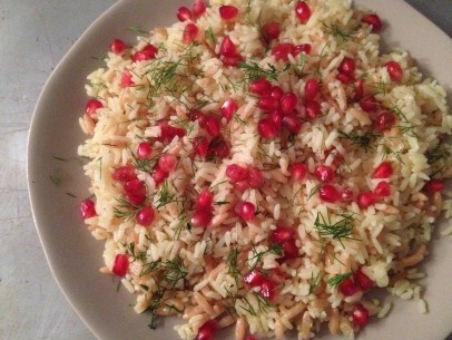 mix pomegranate seeds into platter of steaming rice pilaf